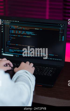 Two hands of a teenager program code for a web page with php on a laptop to practice his studies. Stock Photo