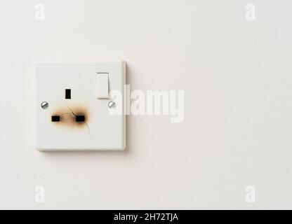 Fire damaged electrical power socket with copy space Stock Photo