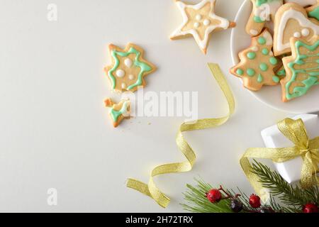 Plate with christmas cookies decorated with sugar and christmas decoration on white table. Top view. Horizontal composition. Stock Photo