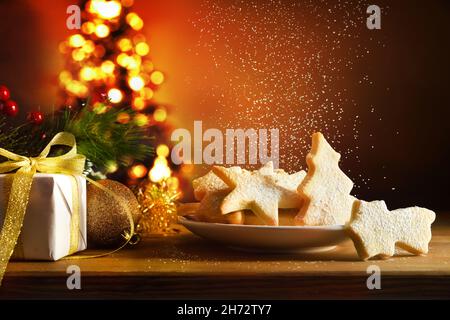 Wooden table with cookies with freshly prepared Christmas shapes on plate with Christmas decoration isolated white background. Front view. Horizontal Stock Photo