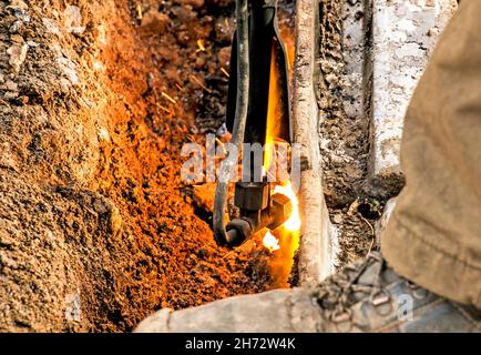 Close-up of the hand of an industrial worker working on the process of cutting rails. A male worker cuts steel using a plasma cutter. Stock Photo