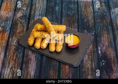 Mozzarella sticks are long pieces of mozzarella cheese that are battered or breaded and fried. Often served in restaurants as an aperitif Stock Photo