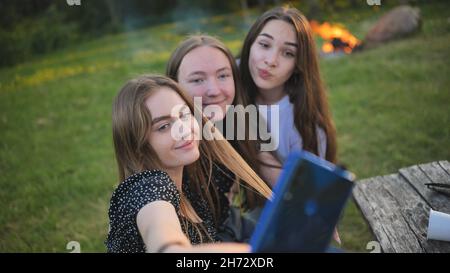 Three schoolgirls make selfies using a smartphone. Stock Photo