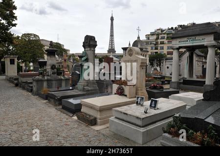 The Eiffel Tower stands in the background beyond rows of graves at the historic Passy Cemetery (Cimetière de Passy) in Paris. Stock Photo