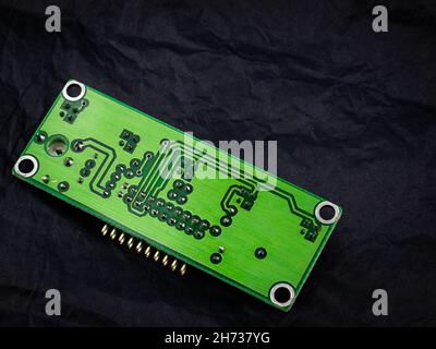 Green printed circuit board on dark textured background, ideal for technology, electronics, hardware development, innovation concepts, and modern digi Stock Photo