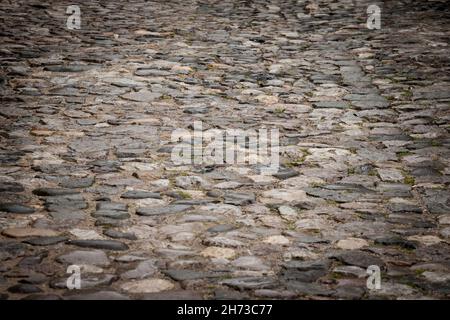 Picture of a road made of cobblestone, decaying, used as pavement. Stock Photo
