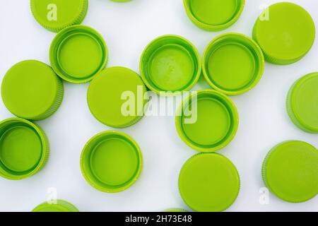 Green caps from plastic bottles on white background flat lay Stock Photo