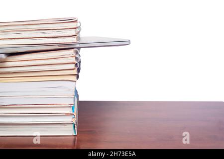 Laptop in a stack of books isolated on white background Stock Photo