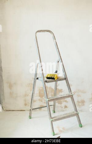 Building stepladder is in the empty room, prepared for renovation. Stock Photo