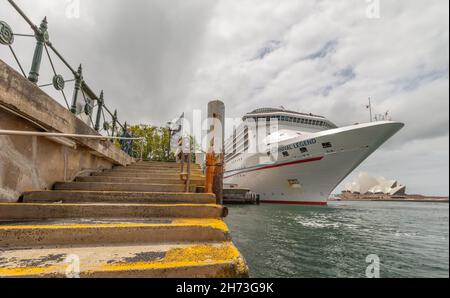 Sydney, Australia - October 23, 2018: Low angle shot of Carnival Legend docked in Sydney Harbour. Old stairway covered with yellow mold in the foregro Stock Photo