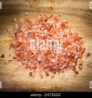 Pile of pink Himalayan rock salt on a wooden cutboard Stock Photo