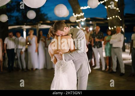 Groom hugs bride in dance in restaurant Stock Photo