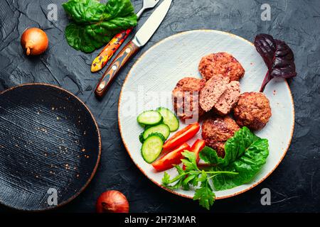 Delicious dietary veal cutlets. Steam cutlets and sliced vegetables Stock Photo
