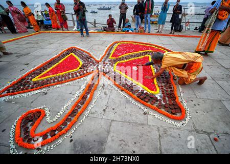 Varanasi, India. 19th Nov, 2021. A Hindu devotee is seen making decorations on the eve of dev Deepavali.Dev Deepavali is the biggest Light Festival of India where devotees decorate the river bank of Ganges with millions of Lamps as part of the festival. (Photo by Avishek Das/SOPA Images/Sipa USA) Credit: Sipa USA/Alamy Live News Stock Photo