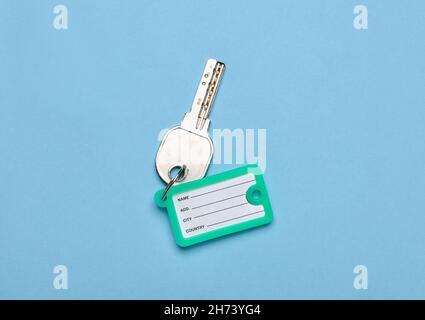 Key with plastic tag on blue background Stock Photo