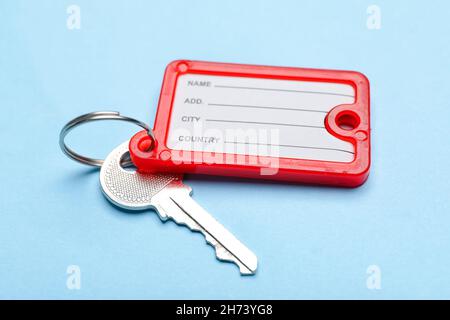 Key with red plastic tag on blue background Stock Photo
