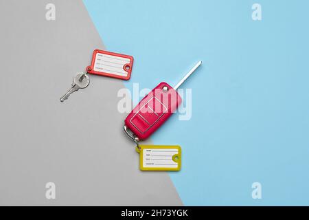Keys with plastic tags on blue and grey background, top view Stock Photo