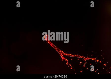 Splash of red liquid on black background Stock Photo