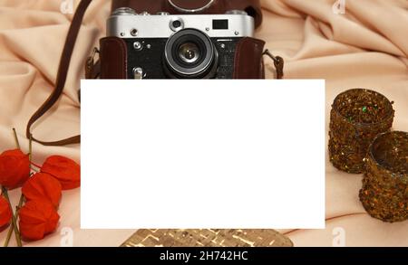 Film camera in case, notebook, fisalis and candlesticks lie on a light beige background. Flatlay Stock Photo