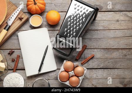 Recipe book and ingredients for pumpkin pie on wooden background Stock Photo
