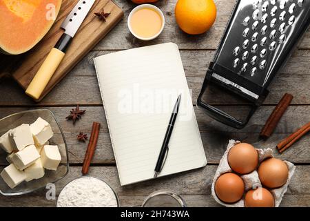 Recipe book and ingredients for pumpkin pie on wooden background Stock Photo
