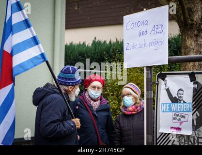 Frankfurt, Germany. 20th Nov, 2021. 20 November 2021, Hessen, Frankfurt/Main: Counter-demonstrators stand at the edge of the hall where the state party conference of the Hessian AfD is taking place. A poster says 'Corona and AfD, two that like each other'. The Hessian AfD is electing a new state executive committee and is also expected to vote on whether the state association should continue to be led by a dual leadership. Photo: Frank Rumpenhorst/dpa Credit: dpa picture alliance/Alamy Live News Stock Photo