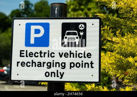A sign indicating an electric vehicle recharging point or parking space in a car park Stock Photo