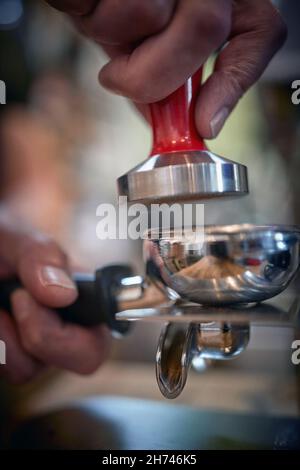 Close-up view of barman's hands who is using accessories for making an aromatic and fragrant espresso. Coffee, beverage, bar Stock Photo