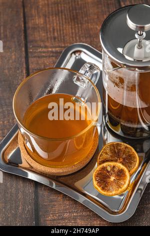 Hot winter tea served with a french press on a wooden floor. Stock Photo