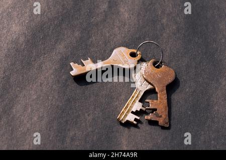 Bunch of old House Key isolated on a rustic Floor. High Angle View. Copy space room for text. Safety secure protection background concept. Stock Photo
