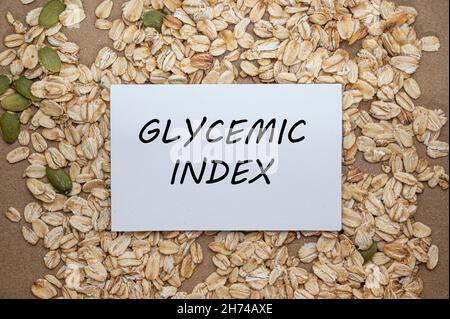 Top view of card with text Glycemic index on oat and seeds background. Healthy eating concept. Stock Photo