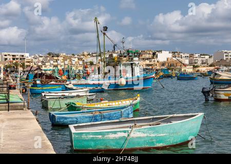 Picturesque view of Marsaxlokk harbour with  traditional colourful fishing boats moored at the quayside, Marsaxlokk village, Malta, Europe Stock Photo