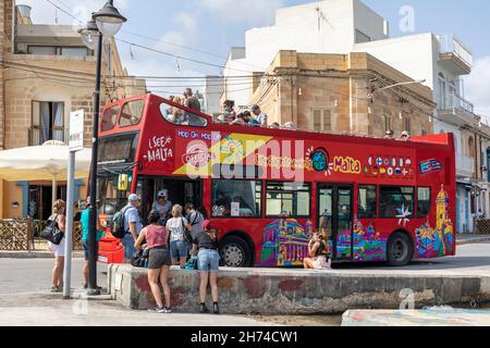 Red City Sightseeing double decker, hop on hop off, open top tour bus at a bus stop in Marsaxlokk, Malta, Europe