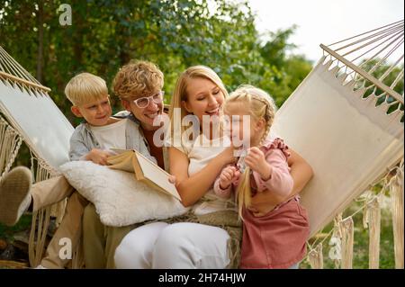 Cheerful family having fun on hammock, camping Stock Photo