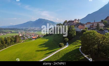 Aerial view of the countryside around the old town of Gruyeres, with the small city of Bulle and the mountains in the background. Gruyeres, Friburgo, Stock Photo