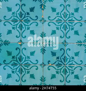 Fragment of building wall with colorful ceramic wall tiles. Abstract decorative background. Azulejos, traditional ornate Portuguese architecture. Stock Photo