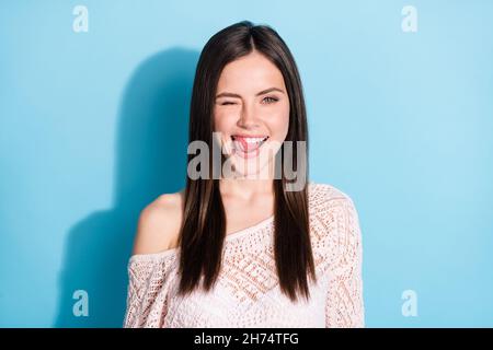 Photo of funky flirty young woman lick teeth tongue wink eye smile isolated on blue color background Stock Photo