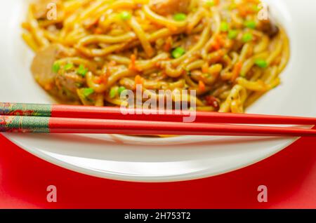 Cooked free range egg noodles with shredded duck in a savoury plum, ginger, chilli and garlic sauce with onions, carrots, pak choi, water chestnuts, o Stock Photo