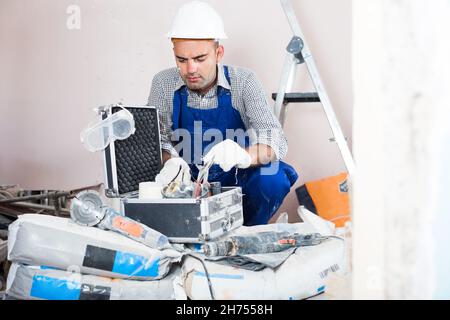 workman searching tools in toolbox Stock Photo