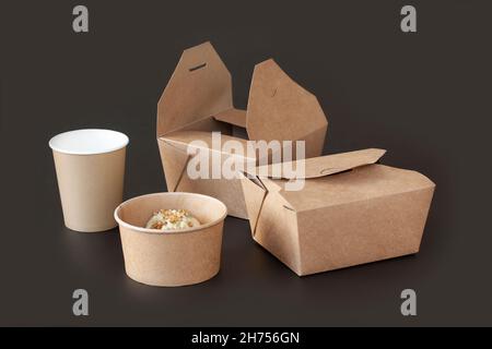Sustainable Food Packaging. Eco-friendly bamboo sustainable and disposable tableware and take-out packaging on black background. Stock Photo