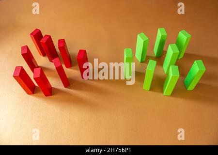 Red and green wooden blocks on colorful background. Conflict between two groups. Concept of competition and competitor in business. Stock Photo