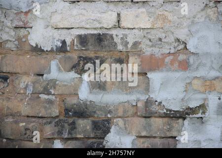 old vintage dirty brick wall with peeling plaster, texture background Stock Photo