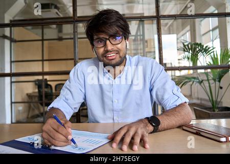 Young Indian financial advisor talking to web camera having virtual meeting. Stock Photo