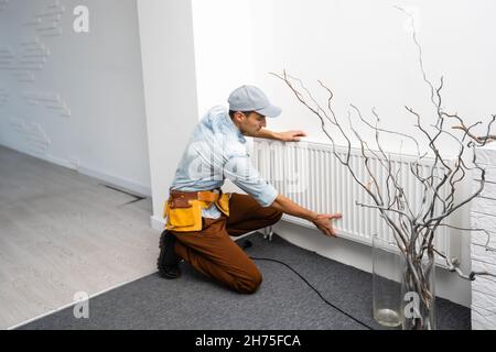 Close-up Of Male Plumber Fixing Thermostat Using Wrench At Home. Stock Photo
