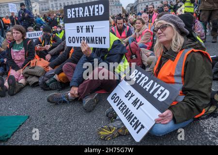 London, UK. 20th Nov 2021. People sit blocking Lambeth Bridge in solidarity with the peaceful protesters from Insulate Britain jailed for breaking an injunction and protesting on the roads in an attempt to force the government to insulate homes as a vital contribution to combating climate change. Peter Marshall/Alamy Live News Stock Photo