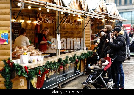 christmas market in the city wooden stall serving food customers waiting family and child in pram Stock Photo