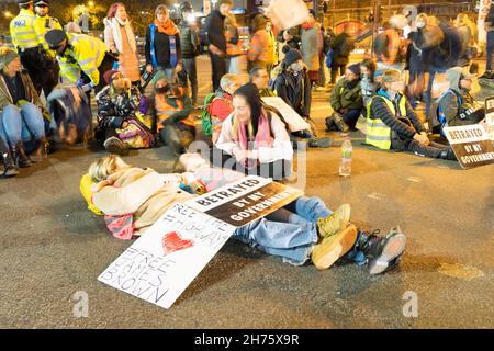 London UK 20th Nov 2021 Activists,  from Insulate Britain, Extinction Rebellion and others, block Vauxhall bridge in London to protest jailing of M25 eco demonstrators, block evening rush hour traffic crossing the river Thames. Heavy police officers present to encourage the activists to leave the area, some of them were carried away by officers off the road to allow the traffic to resume. Credit: Xiu Bao/Alamy Live News Stock Photo