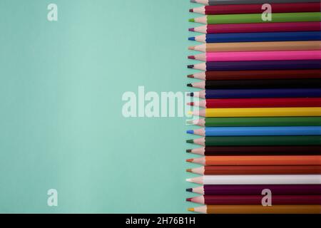 A closeup shot of pencils of different sizes on a green background Stock Photo