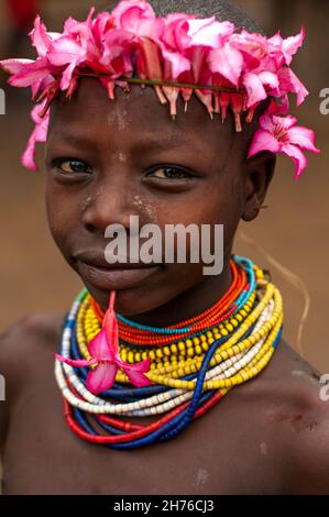 young boy from the Karo tribe with colorful beads and flowers on his head for decoration Stock Photo