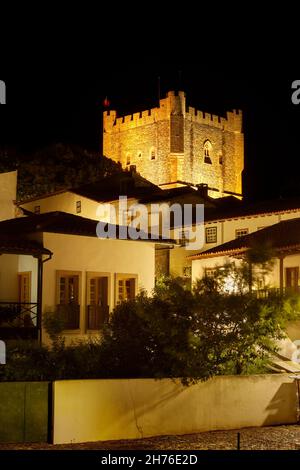 Bragança, Portugal - June 26, 2021: Keep of Bragança Castle in Portugal, illuminated at night, with houses from the citadel in the foreground. Stock Photo